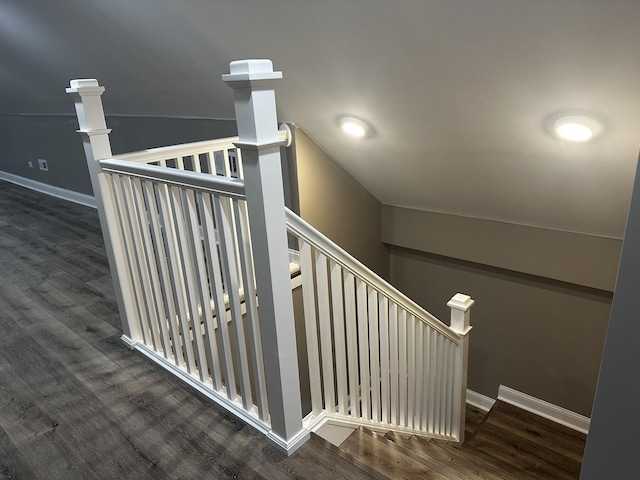 stairway featuring wood-type flooring and vaulted ceiling