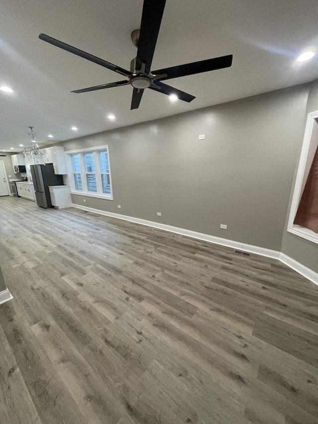 unfurnished living room with wood-type flooring and ceiling fan