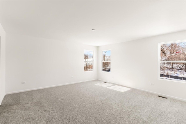 carpeted empty room with visible vents and baseboards