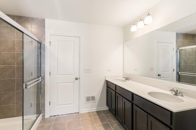 bathroom with double vanity, visible vents, a sink, and tile patterned floors