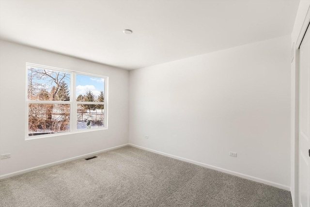 carpeted empty room with baseboards and visible vents