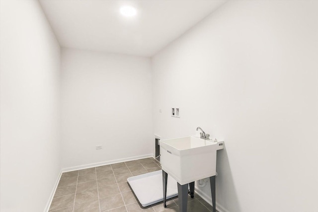 laundry area with laundry area, hookup for a washing machine, baseboards, and light tile patterned floors