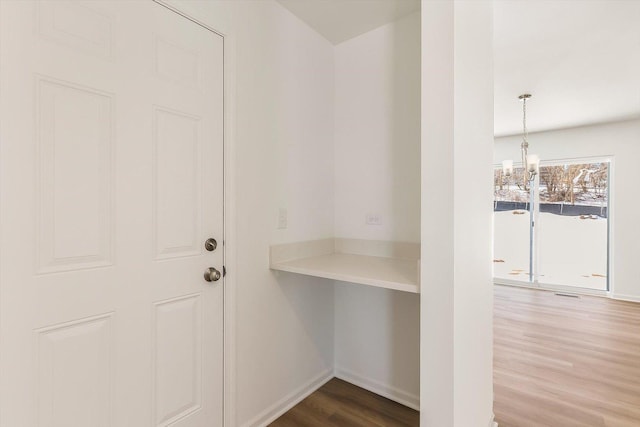 interior space featuring wood finished floors and a notable chandelier