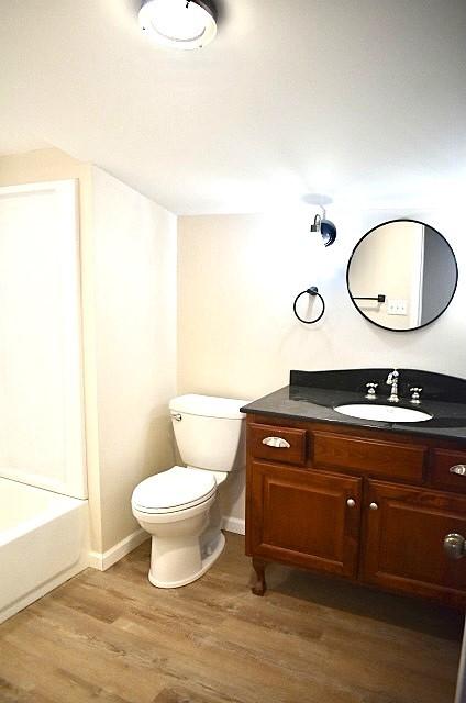 bathroom with hardwood / wood-style floors, vanity, and toilet