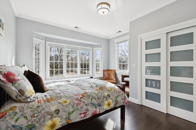 bedroom featuring dark wood-style floors, a closet, visible vents, and crown molding