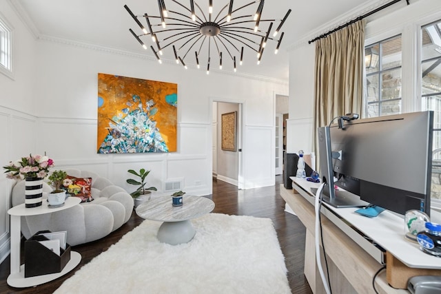 living room with a notable chandelier, a decorative wall, visible vents, ornamental molding, and dark wood finished floors