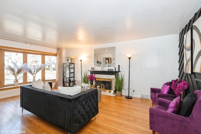 living room featuring light hardwood / wood-style flooring and a high end fireplace