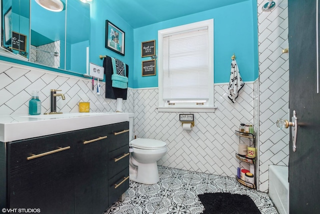 bathroom featuring tile patterned flooring, vanity, toilet, and tile walls