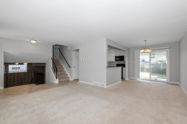 unfurnished living room with plenty of natural light, light colored carpet, and an inviting chandelier