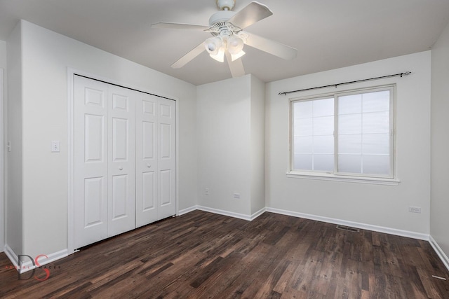 unfurnished bedroom featuring dark hardwood / wood-style flooring, a closet, and ceiling fan