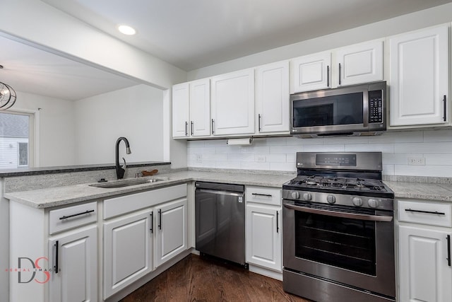 kitchen with tasteful backsplash, sink, white cabinets, and stainless steel appliances