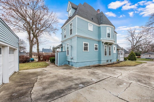 rear view of property with a garage and a yard