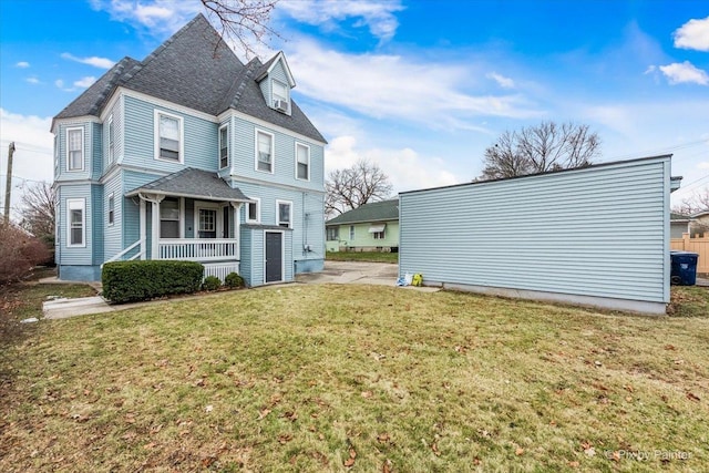 back of property with a lawn and a porch