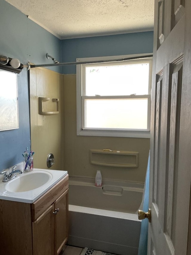 bathroom with a textured ceiling, vanity, tub / shower combination, and tile patterned flooring