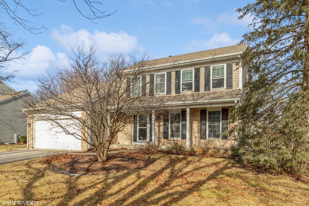 colonial home with a garage and a front yard