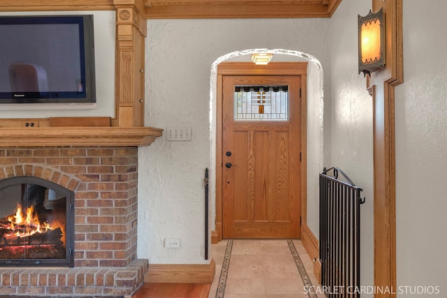 view of exterior entry with a brick fireplace