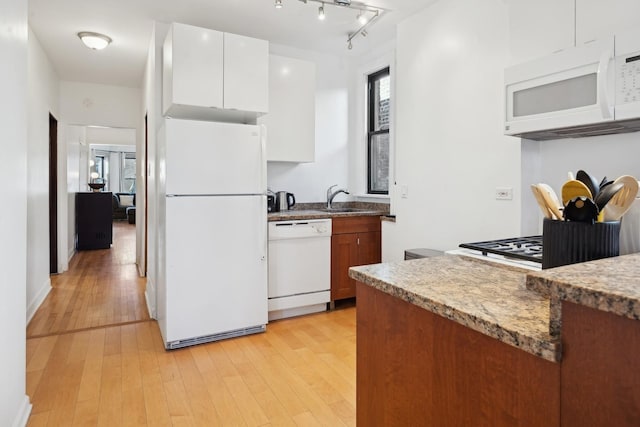 kitchen with sink, light stone counters, white appliances, white cabinets, and light wood-type flooring