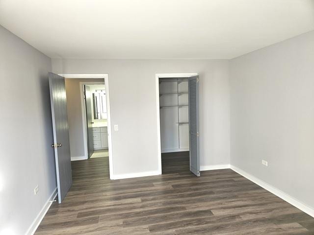 unfurnished bedroom with a closet and dark hardwood / wood-style floors