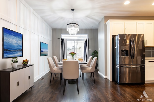 dining room featuring dark hardwood / wood-style floors and an inviting chandelier