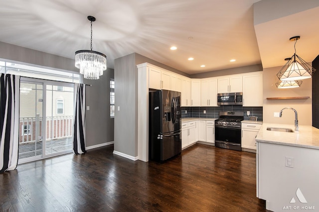 kitchen with sink, hanging light fixtures, light stone counters, white cabinetry, and stainless steel appliances