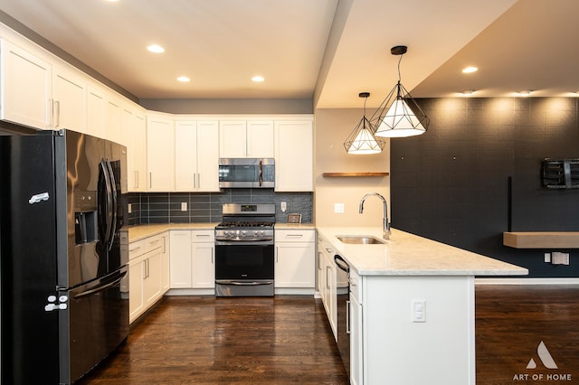 kitchen featuring tasteful backsplash, stainless steel appliances, sink, white cabinets, and hanging light fixtures