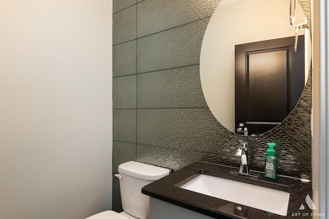 bathroom with decorative backsplash, vanity, and toilet