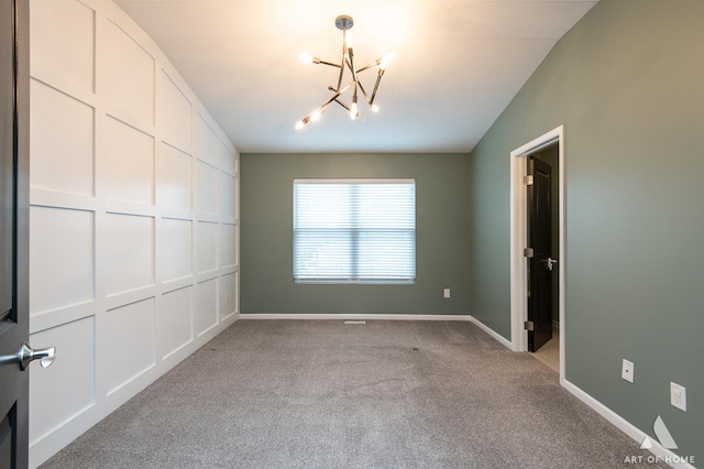 empty room with light colored carpet and an inviting chandelier