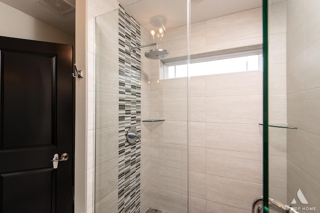 bathroom featuring a shower with door