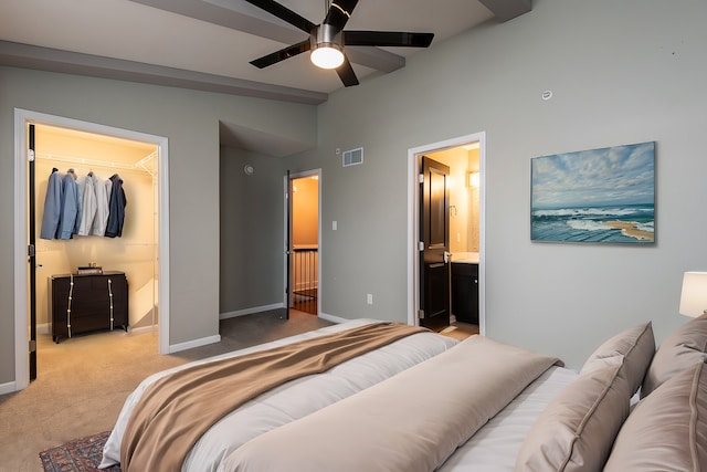 bedroom with light colored carpet, lofted ceiling with beams, a spacious closet, connected bathroom, and a closet