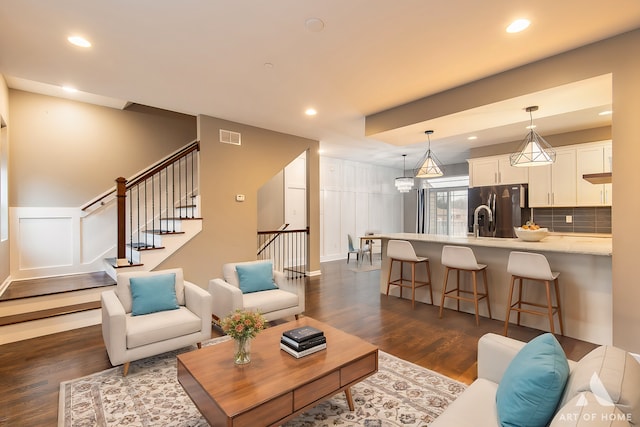 living room featuring a chandelier and dark wood-type flooring