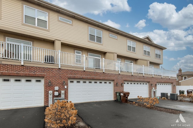 townhome / multi-family property featuring a garage and central air condition unit