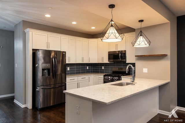 kitchen with white cabinets, sink, hanging light fixtures, appliances with stainless steel finishes, and kitchen peninsula