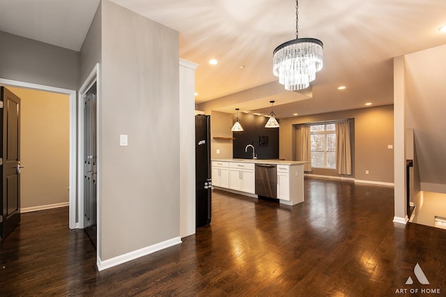 kitchen featuring dishwasher, a chandelier, pendant lighting, black refrigerator, and white cabinets