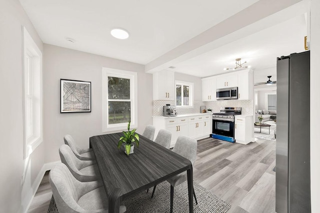 dining room with ceiling fan and light hardwood / wood-style floors