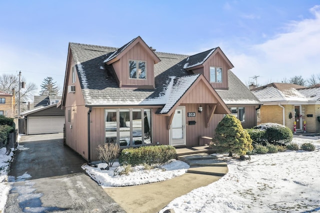 view of front of home featuring a garage and an outbuilding