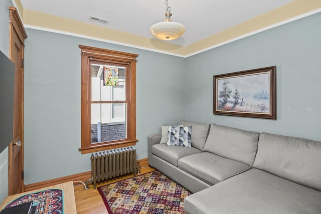 living room featuring radiator heating unit and light wood-type flooring