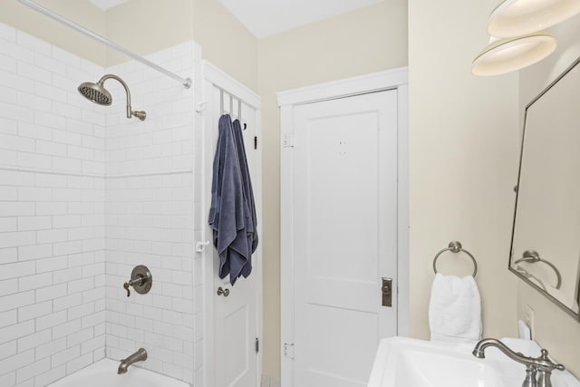 bathroom with tiled shower / bath and sink