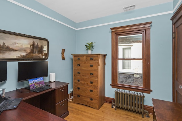 office area with light hardwood / wood-style flooring and radiator