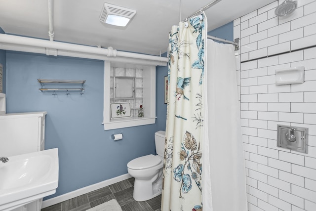 bathroom with toilet, curtained shower, and sink