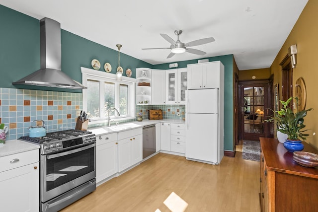 kitchen featuring white cabinets, stainless steel appliances, and wall chimney range hood