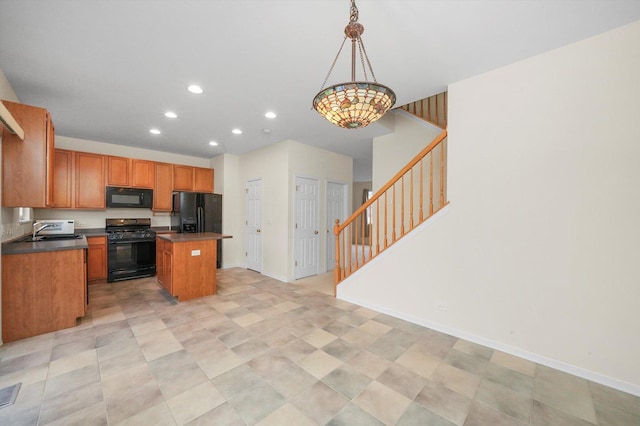 kitchen featuring black appliances, a kitchen island, sink, and pendant lighting