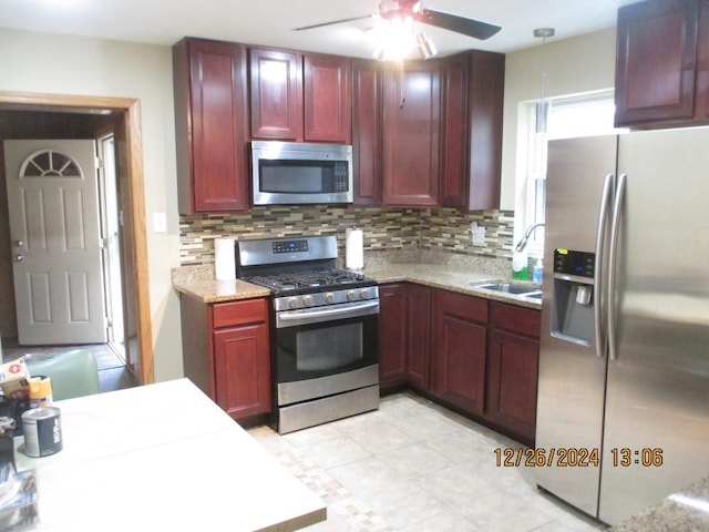 kitchen featuring backsplash, ceiling fan, sink, and stainless steel appliances