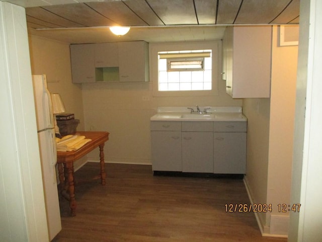 kitchen with dark hardwood / wood-style floors, white refrigerator, white cabinetry, and sink