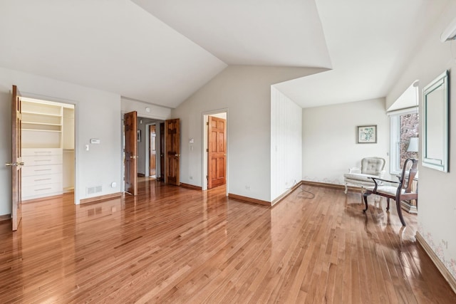 interior space with lofted ceiling and light hardwood / wood-style flooring