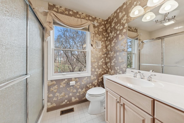 bathroom with vanity, toilet, and a healthy amount of sunlight