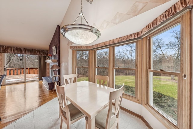 dining area with vaulted ceiling and light tile patterned flooring