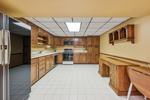 kitchen with a paneled ceiling, sink, and black appliances