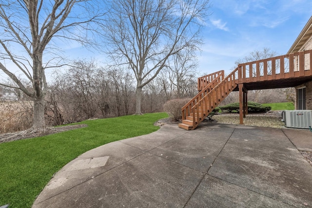 view of yard featuring central air condition unit, a wooden deck, and a patio area