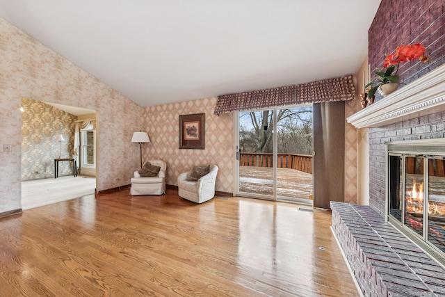 unfurnished room with hardwood / wood-style flooring and a brick fireplace