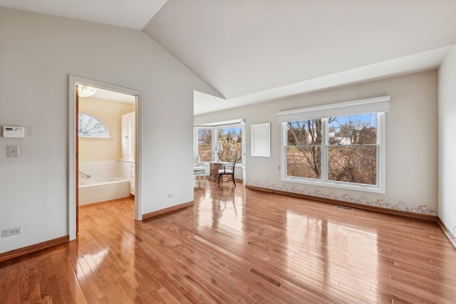 unfurnished living room featuring light hardwood / wood-style flooring and lofted ceiling